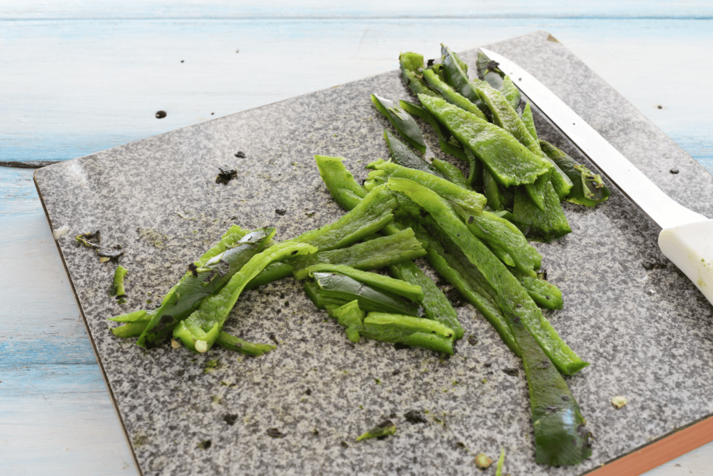 prepping and cutting up poblano peppers to preserve